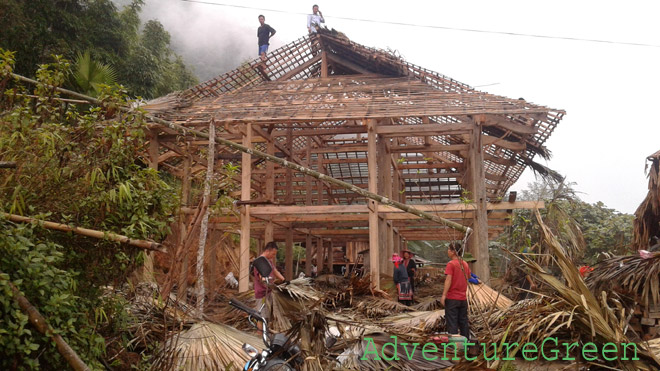 Villagers are putting up the roof of a new house