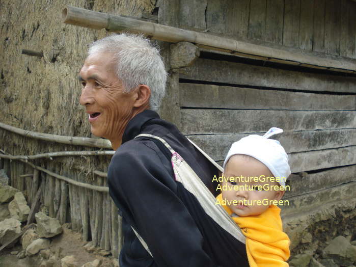 A Tay old man carrying his grandson at a village in Cao Bang