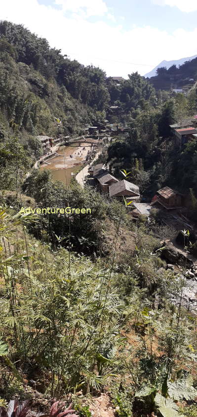 Hmong houses on the sides of the river at the Cat Cat Waterfall