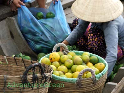 A fruit trader at Cai Be Floating Market in Vinh Long, Vietnam