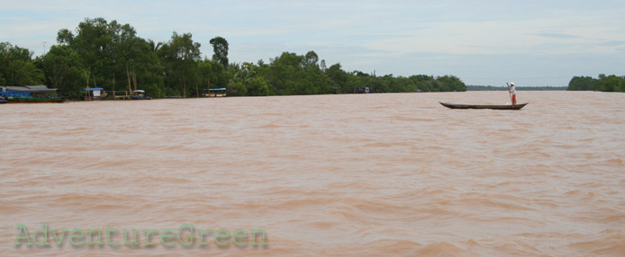 A lady rowing a boat on the vast Mekong River at Tien Giang