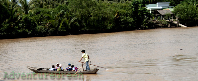A rowing boat carrying kids to school at Tra Vinh A rowing boat carrying kids to school at Tra Vinh