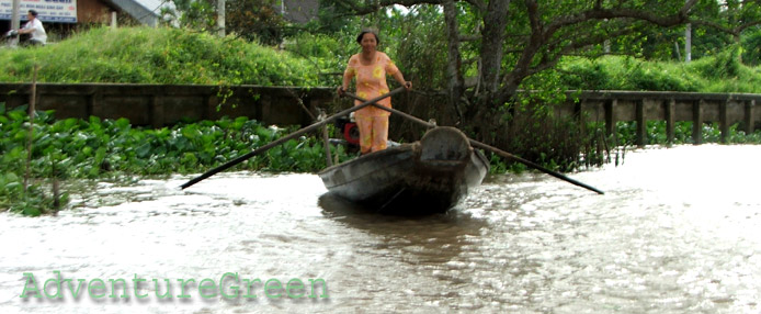 A lady rowing a boat on the Mekong River at Vinh Long