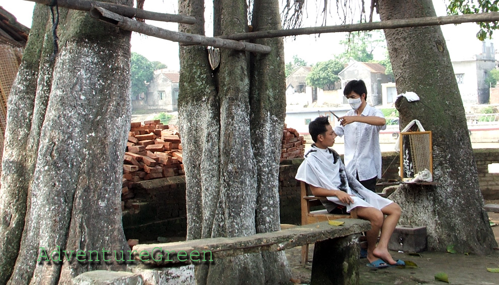 Un coiffeur au travail au village de Tho Ha